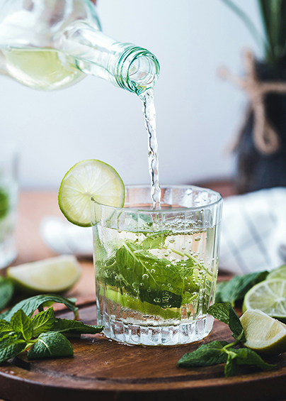 A bottle of gin being poured into a glass.